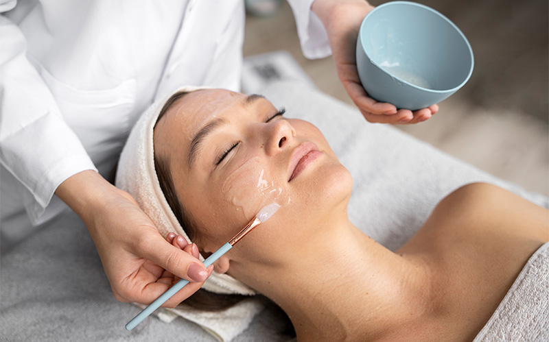 Patient receiving soothing facial treatment application in clinical setting.